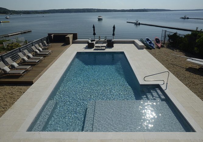 Infinity pool with scenic lake backdrop.