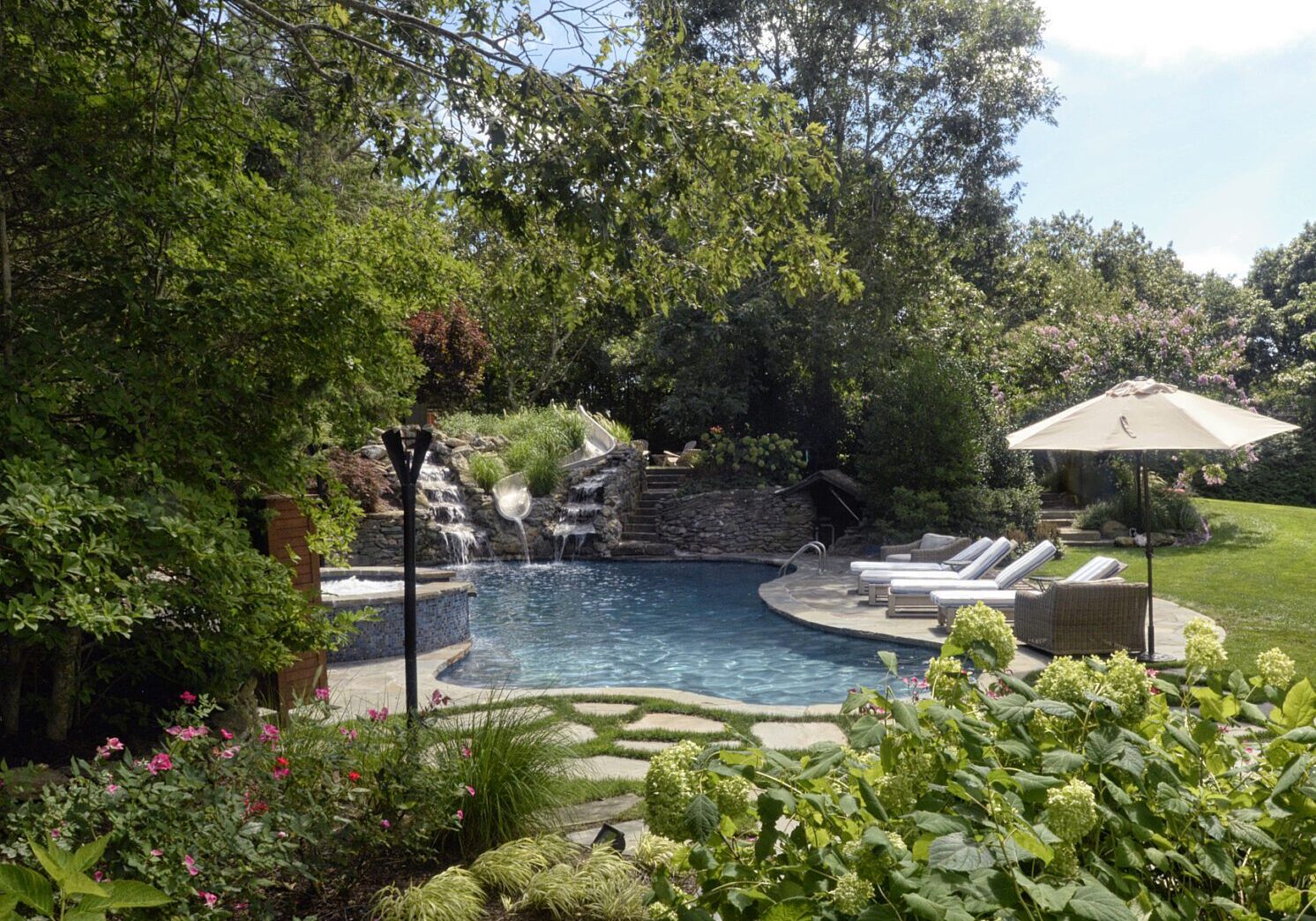 Garden pool with waterfall and loungers