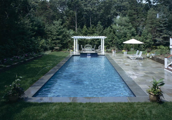 Rectangular pool with pergola and chairs